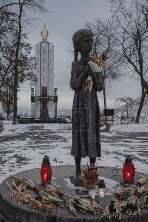 Téléchargez les photos : Kiev, Ukraine. Le 28 novembre 2023, le Musée de l'Holodomor-Génocide du peuple ukrainien. Mémorial d'une petite fille. les gens sont venus le jour du mémorial et ont déposé des fleurs - en image libre de droit