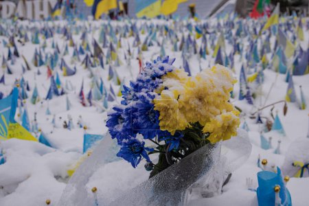 Foto de Kiev, Ucrania - 11 de diciembre de 2023: La gente viene y pone flores en Khreshchatyk en el lugar de la memoria para los defensores caídos de Ucrania. y algunos pusieron un pequeño árbol de Navidad. - Imagen libre de derechos