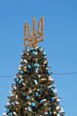 Photo for Kyiv, Ukraine - December 20, 2023: a New Year's tree with a Ukrainian trident on top was put up on Sofiyivska Square in Kyiv. A flag of Ukraine was placed nearby. - Royalty Free Image