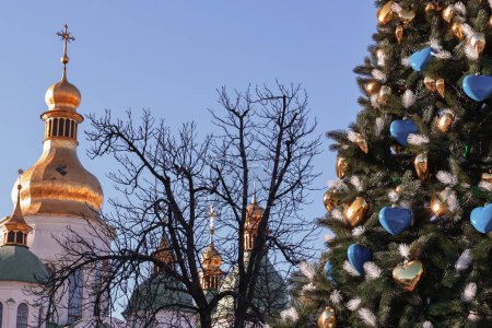 Photo for Kyiv, Ukraine - December 20, 2023: a New Year's tree with a Ukrainian trident on top was put up on Sofiyivska Square in Kyiv. A flag of Ukraine was placed nearby. - Royalty Free Image
