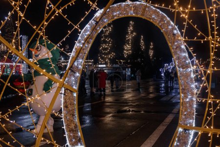 Téléchargez les photos : Kiev, Ukraine - 26 décembre 2023 : VDNG a tout décoré pour le Nouvel An. le soir, les gens sont venus se reposer après le travail. patiner, bavarder avec des amis. Buvez des boissons chaudes et mangez de délicieux aliments. - en image libre de droit