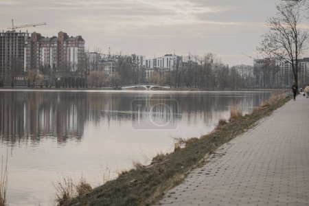 Ivano-Frankivsk, Ukraine. February 28, 2024, a small European city. At the end of February, the weather is very warm, people are walking by the lake. feed the birds and play sports