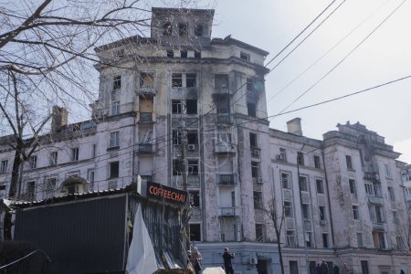 Téléchargez les photos : Kiev, Ukraine. Tôt dans la matinée du 21 mars 2024, les Russes ont tiré des missiles sur la ville. maisons endommagées, des voitures et un gouffre sur la route. les gens sont venus pour aider à nettoyer. - en image libre de droit
