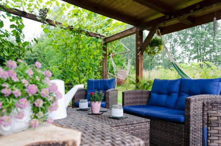 Photo for Beautiful covered terrace with green garden and natural wood, rattan furniture, hammock. Summer outdoor and relax in patio. - Royalty Free Image