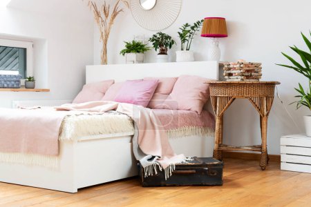 Foto de Cómoda cama con almohadas de color rosa brillante y manta en el acogedor dormitorio. Interior de la habitación con elegante mesa en el hotel para descansar y relajarse. - Imagen libre de derechos