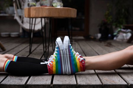 Foto de Lgbt símbolo en los zapatos de arco iris en las piernas de un par de mujeres. Dos lesbianas en calzado colorido al aire libre. Dos chicas sexy como concepto de amor, libertad y diversidad. - Imagen libre de derechos