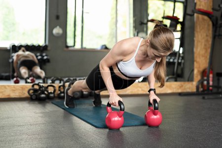 Photo for Full body woman. Female athlete training plank exercise on mat with heavy dumbbells during. Woman workout in gym. Healthy lifestyle. - Royalty Free Image
