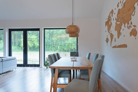 Téléchargez les photos : Table à manger avec chaises confortables, sol en bois, décoration au mur et lampe élégante sur la table à l'intérieur moderne à la maison neuve. - en image libre de droit