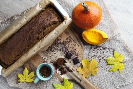 Photo for Autumn food for lunch with pumpkin bread as a homemade healthy baking. Rustic style in the kitchen on a wooden table with yellow leaves. Top view dessert. - Royalty Free Image