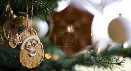 Photo for Christmas decoration on tree . Handmade christmas cookies hanging on the green fir. Santa Claus.Banner. - Royalty Free Image