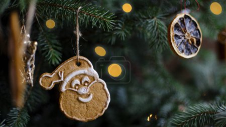 Téléchargez les photos : Arbre de Noël sur fond vert avec décoration de Noël à la main. Biscuit de Noël Père Noël et lumières de fées sur la carte de Noël. - en image libre de droit