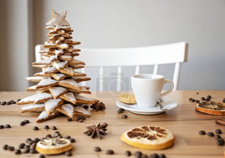 Foto de Árbol de Navidad hecho en casa hecho de galletas para Navidad y taza de café blanco con decoración de Navidad en una mesa de madera en un interior acogedor. Relajación en el café. espacio de copia. - Imagen libre de derechos