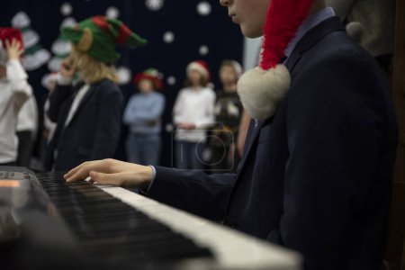 Photo for Christmas musican performance of children in school with keyboard. Kids play and dance on a stage with music. Concert of people. - Royalty Free Image