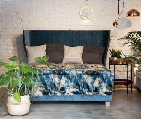 Téléchargez les photos : Lit moderne et élégant de couleur bleue dans l'appartement loft. Intérieur industriel avec mur de briques blanches et design contemporain. - en image libre de droit