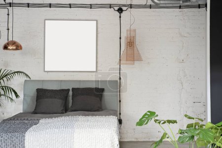 Photo for Modern interior of a bedroom in grey and white color. Loft apartment with luxury table and lamps. Blank frame with mock up. - Royalty Free Image