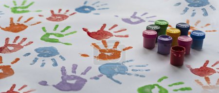 Téléchargez les photos : Impressions de mains colorées sur fond blanc avec des peintures. Empreinte des petits enfants de palmiers comme un plaisir, un jeu et une éducation à la maternelle. Gros plan - en image libre de droit