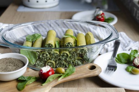 Téléchargez les photos : Canellonis de pâtes vertes pour le dîner végétarien avec parmesan et épinards. Aliments sains préparés à la maison pour le régime italien. Repas sur la table dans la cuisine. - en image libre de droit