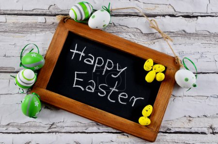 Photo for Easter card with Happy Easter text in frame on board with decorative easter eggs on wooden background. - Royalty Free Image