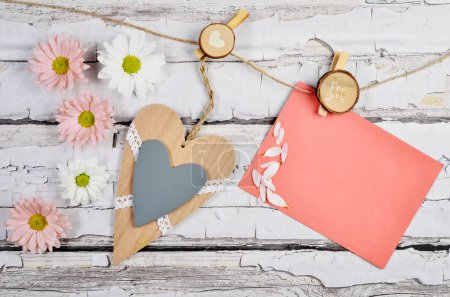 Photo for Blank paper on greeting card to wishing love. Wooden background with flowers and heart shape. Mother's day. Overhead view and copy space. - Royalty Free Image