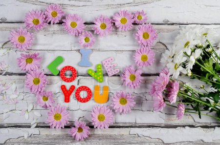 Téléchargez les photos : Carte de fête des mères pour les salutations avec coeur à base de fleurs roses sur fond en bois. Vacances et amour. - en image libre de droit