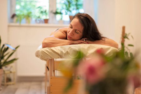 Téléchargez les photos : Femme de 40 ans se détendre après le massage dans le salon de spa. Bien-être et mode de vie sain. - en image libre de droit