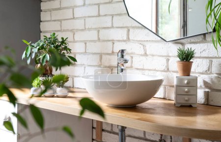 Photo for Bathroom with white bricks wall, stylish wash basin, mirror and a lof of green plants. Spa at home and houseplant. Cozy and minimalist interior. - Royalty Free Image