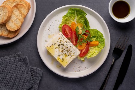 Téléchargez les photos : Photographie culinaire de salade de fromage feta, grec, tomate, romaine, fromage, laitue, assaisonnement, huile d'olive, pain grillé - en image libre de droit