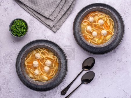 Photo for Food photography of soup with meatballs and noodles, vegetables, carrot, chive, potatoes - Royalty Free Image