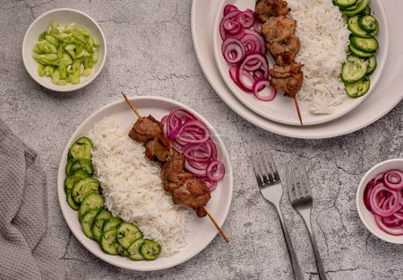 Photo for Food photography of grilled meat, kebab, bbq, roasted, pork, lamb, marinade, onion, rice, salad, cucumber - Royalty Free Image