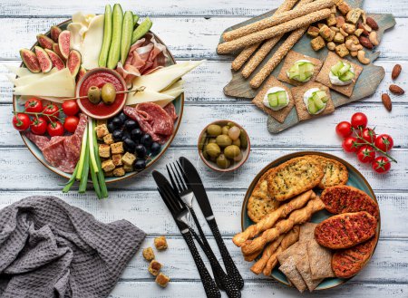 Foto de Fotografía gastronómica de antipasto, comida mediterránea, aperitivo, snacks, queso, jamón sobre fondo de madera blanca - Imagen libre de derechos