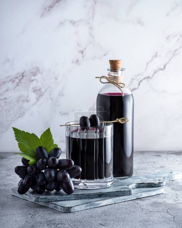 Téléchargez les photos : Photographie de jus de raisin, vin rouge, raisin, verre, bouteille sur fond de marbre - en image libre de droit