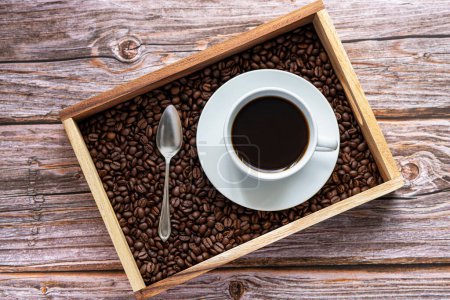 Foto de Fotografía de café negro, granos de café, cuchara, caja de madera, fondo de madera - Imagen libre de derechos