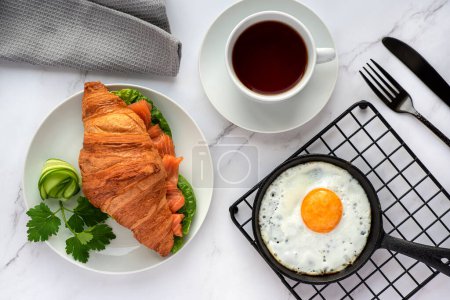Photo for Food photography of breakfast, croissant, fried egg, tea, salmon sandwich - Royalty Free Image