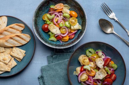 Photo for Food photography of salad, tomato, onion, artichoke, toasts - Royalty Free Image