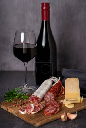 Téléchargez les photos : Photographie culinaire de vin, salami tranché, saucisse, fromage, ail, poivre, romarin - en image libre de droit