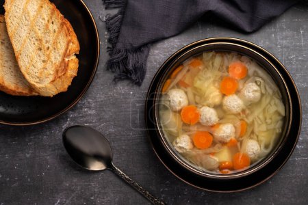 Foto de Fotografía de alimentos de sopa con albóndigas, pollo, verduras, zanahorias, col, papas, tostadas - Imagen libre de derechos
