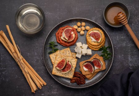 Foto de Fotografía gastronómica de vino, queso blando, salami, higos, galletas saladas, feta, grissini - Imagen libre de derechos