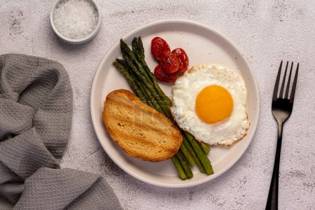 Photo for Food photography of fried egg, tomato, asparagus, toast, salt, breakfast - Royalty Free Image
