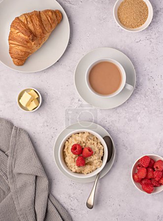 Photo for Food photography of oatmeal, oat, porridge, breakfast, croissant, tea, milk, raspberries, butter - Royalty Free Image