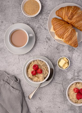 Photo for Food photography of oatmeal, oat, porridge, breakfast, croissant, tea, milk, raspberries, butter - Royalty Free Image