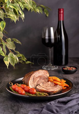 Photo for Food photography of roasted lamb, carrot, asparagus, tomato, red wine, bottle, wineglass - Royalty Free Image