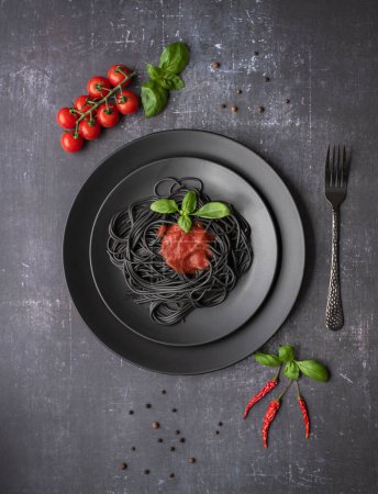 Téléchargez les photos : Food photography of black spaghetti, tomato sauce, tomatoes, basil - en image libre de droit