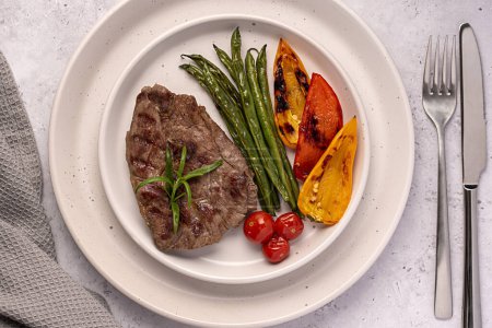 Téléchargez les photos : Photographie culinaire de steak d'agneau rôti, grillé, viande, filet, haricots verts, paprika, tomates cerises - en image libre de droit
