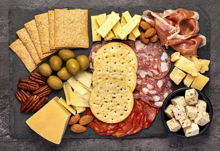Photo for Macro food photography of antipasto, cheese, cheddar, cracker, parmesan, salami, prosciutto, feta, almond, pecan, dip, mediterranean food - Royalty Free Image