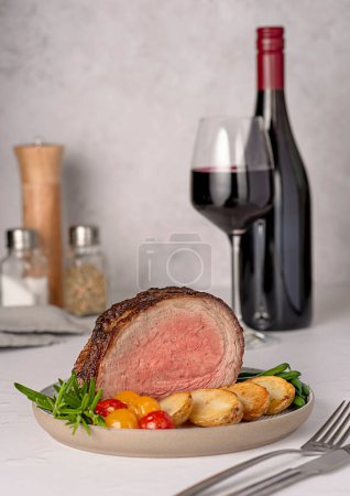 Photo for Food photography of roasted beef brisket, fillet; fried, potatoes, bean, rosemary, pepper, seasoning, red; wine; bottle; wineglass - Royalty Free Image