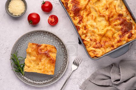 Photo for Food photography of lasagna; casserole; cheese; tomato; sauce; parmesan; plate; towel; stand; ground; rustic; italian; meat; mediterranean; pasta; bolognese - Royalty Free Image