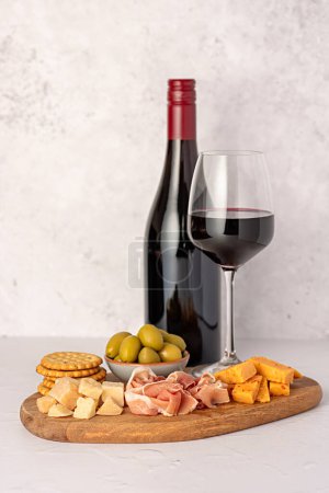 Photo for Food photography of antipasto, red wine, cheese, ham, serrano, olive, prosciutto, bacon, parmesan, cheddar, cracker - Royalty Free Image