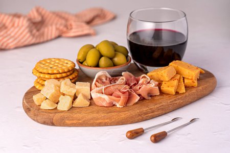 Photo for Food photography of antipasto, red wine, cheese, ham, serrano, olive, prosciutto, bacon, parmesan, cheddar, cracker - Royalty Free Image