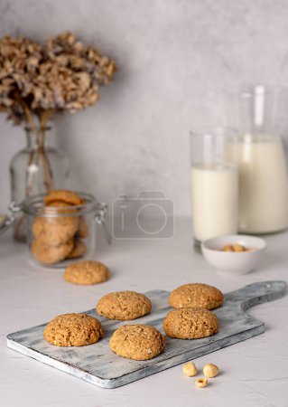 Foto de Fotografía de alimentos de galleta de avena; harina de avena; galleta; nuez; avellana, pastelería, postre; tarro, vidrio, tabla - Imagen libre de derechos