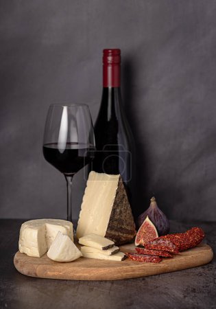 Photo for Food photography of cheese; fig, red wine, dried  salami with paprika, slice; gourmet; delicatessen; background; appetizer; starter, snack - Royalty Free Image